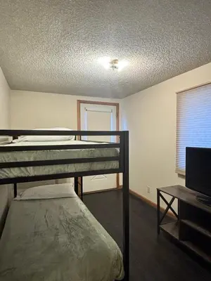 a bedroom with two bunk beds and a television at Yogi Bear's Jellystone Park Camp-Resort in Estes Park in Estes Park