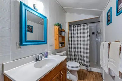 a bathroom with a sink and a toilet and a mirror at Yogi Bear's Jellystone Park Camp-Resort in Estes Park in Estes Park