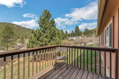 a chair sitting on a deck with a view at Yogi Bear's Jellystone Park Camp-Resort in Estes Park in Estes Park