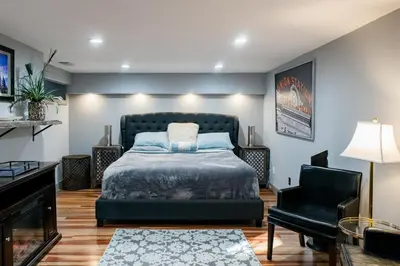 a bedroom with a bed and a black chair at Designer Apartment in a Historic 1901 Downtown Area Mansion in Denver