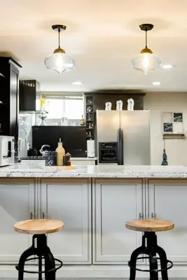 a kitchen with two bar stools at a counter at Designer Apartment in a Historic 1901 Downtown Area Mansion in Denver