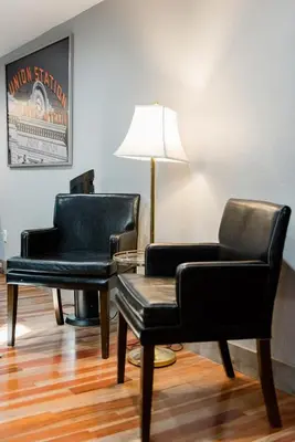 two chairs and a table and a lamp in a room at Designer Apartment in a Historic 1901 Downtown Area Mansion in Denver