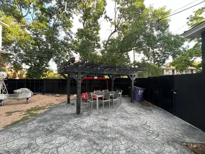 a backyard with a wooden pergola and a table and chairs at Designer Apartment in a Historic 1901 Downtown Area Mansion in Denver