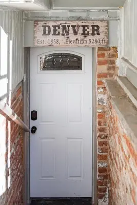 a white garage door with a sign above it at Designer Apartment in a Historic 1901 Downtown Area Mansion in Denver