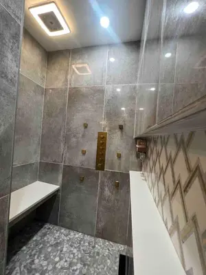 a bathroom with a shower with a tile wall at 4 BR Luxurious-Gem Mansion in Heart of Denver in Denver