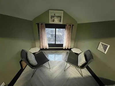 a living room with two chairs and a window at 4 BR Luxurious-Gem Mansion in Heart of Denver in Denver