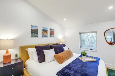 a bedroom with a bed with blue and white pillows at Less Than 1 Block to City Park New-Build Apt in Denver! in Denver