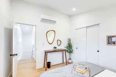 a white bedroom with a bed and a mirror at Less Than 1 Block to City Park New-Build Apt in Denver! in Denver