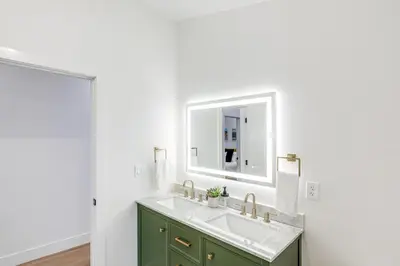 a bathroom with a sink and a mirror at Less Than 1 Block to City Park New-Build Apt in Denver! in Denver