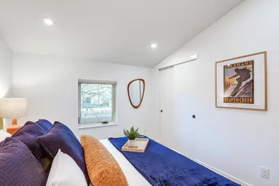 a living room with a couch and a mirror at Less Than 1 Block to City Park New-Build Apt in Denver! in Denver