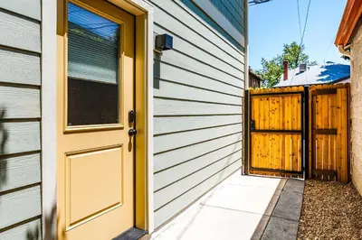 a door to a house with a fence at Less Than 1 Block to City Park New-Build Apt in Denver! in Denver