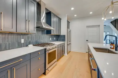 a kitchen with white cabinets and a stove top oven at 13 Mi to Boulder Family-Friendly Home in Erie! in Erie