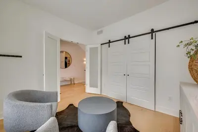 a living room with a gray chair and a sliding door at 13 Mi to Boulder Family-Friendly Home in Erie! in Erie