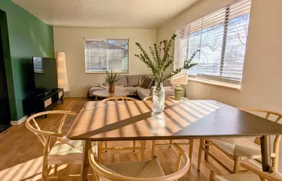 a dining room with a table and chairs and a couch at Joy House in Golden
