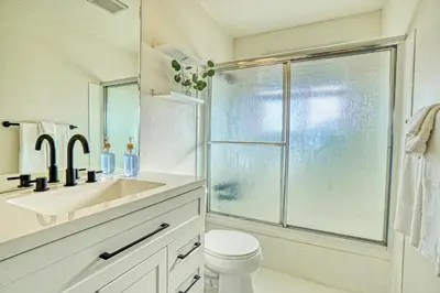 a white bathroom with a sink and a shower at Joy House in Golden