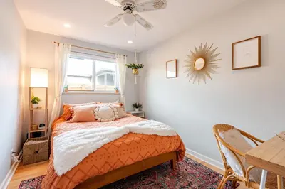 a bedroom with a bed and a table and a window at Boho Cozy House with bikes, 2 blocks to Sloans Lake! in Denver