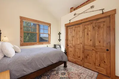 a bedroom with a large wooden closet and a bed at 19th Hole cabin in Granby