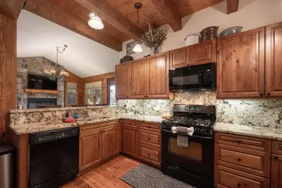 a kitchen with wooden cabinets and black appliances at 19th Hole cabin in Granby
