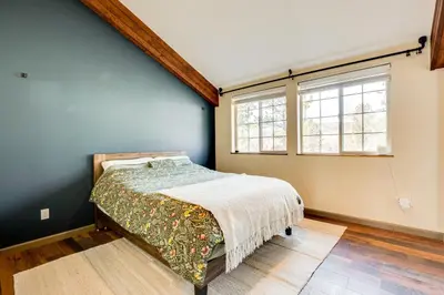 a bedroom with a bed and two windows at 3 Mi to Casinos Cabin with Stables in Black Hawk! in Black Hawk