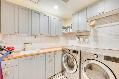 a kitchen with white cabinets and a washer and dryer at 3 Mi to Casinos Cabin with Stables in Black Hawk! in Black Hawk