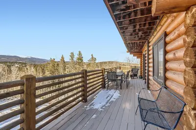 a deck with chairs and a fence on a cabin at Valley View Vistas lodge in Nederland