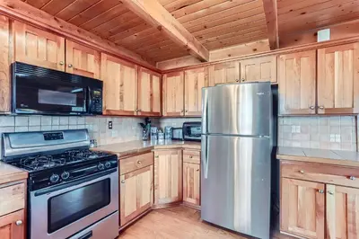 a kitchen with wooden cabinets and a stainless steel refrigerator at Valley View Vistas lodge in Nederland