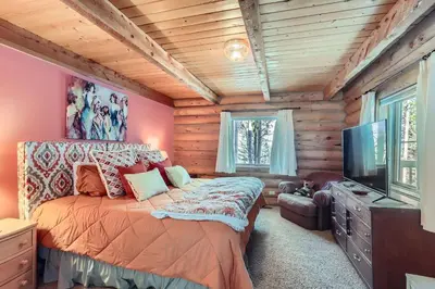 a bedroom with a bed and a flat screen tv at Valley View Vistas lodge in Nederland