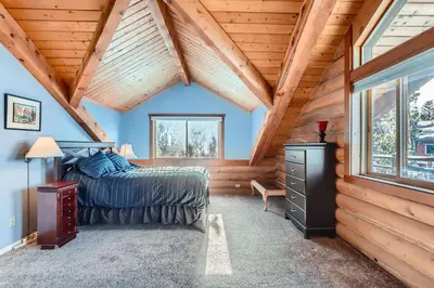 a bedroom in a log cabin with a bed and a window at Valley View Vistas lodge in Nederland