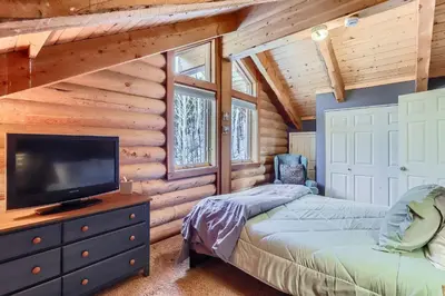 a bedroom with a bed and a television in a log cabin at Valley View Vistas lodge in Nederland