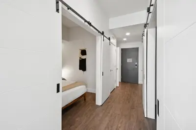 a bedroom with white walls and a bed and a closet at Urban Elegance at Espadin in Denver