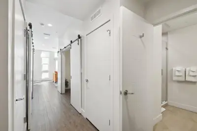 a hallway with white walls and white doors at Urban Elegance at Espadin in Denver