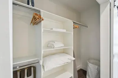 a small closet with white shelves and a bed at Urban Elegance at Espadin in Denver