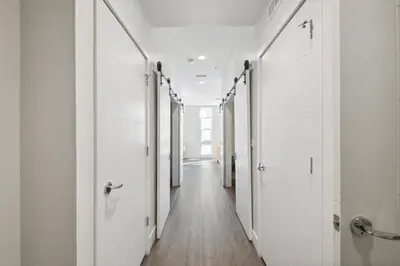 a hallway with white doors and wooden floors at Urban Elegance at Espadin in Denver