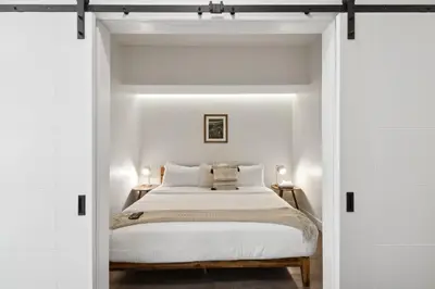a bedroom with white walls and a bed with white sheets at Urban Elegance at Espadin in Denver