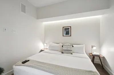 a white bedroom with a large bed with white walls at Urban Elegance at Espadin in Denver