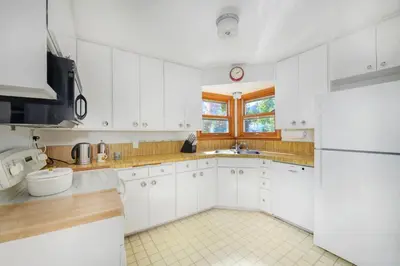 a white kitchen with a sink and a refrigerator at 5 minute drive to Pearl Street - Best Neighborhood in Boulder in Boulder