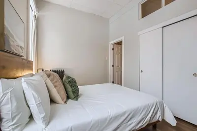 a bedroom with a large white bed with pillows at Cloud by Modern Midstay - 1 Block to City Park #C1 in Denver