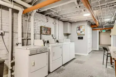 a laundry room with white appliances and a brick wall at Cloud by Modern Midstay - 1 Block to City Park #C1 in Denver