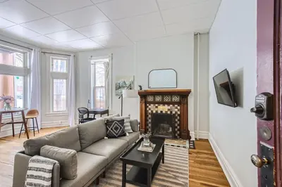a living room with a couch and a fireplace at Cloud by Modern Midstay - 1 Block to City Park #C1 in Denver