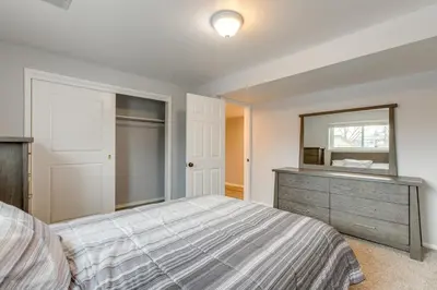 a bedroom with a bed and a dresser and a mirror at 12 Mi to Dtwn Denver Home with Fenced Backyard! in Northglenn