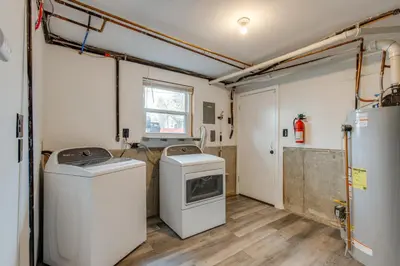 a laundry room with two machines and a washer and dryer at 12 Mi to Dtwn Denver Home with Fenced Backyard! in Northglenn