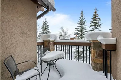a balcony covered in snow with a table and chairs at 107 Red Quill in Winter Park