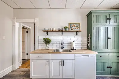 a kitchen with white and green cabinets and a sink at Cloud by Modern Midstay - 1 Block to City Park #C5 in Denver
