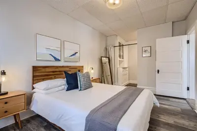 a bedroom with a large white bed with blue pillows at Cloud by Modern Midstay - 1 Block to City Park #C5 in Denver