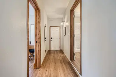 a hallway with a mirror and a white door at 1st Ave by Modern Midstay - Wash Park & SoBo #F2 in Denver