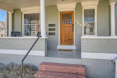a house with a brown door and a porch at 1st Ave by Modern Midstay - Wash Park & SoBo #F2 in Denver