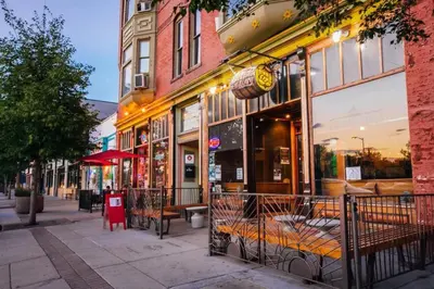 a street scene of a store front with a bench at 1st Ave by Modern Midstay - Wash Park & SoBo #F2 in Denver