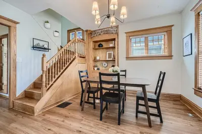 a dining room with a table and chairs and a staircase at 1st Ave by Modern Midstay - Wash Park & SoBo #F2 in Denver