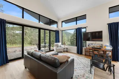 a living room with a couch and large windows at Pineview Panorama Luxe Retreat 20 Mins to Boulder in Jamestown