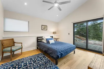 a bedroom with a bed and a chair and a window at Pineview Panorama Luxe Retreat 20 Mins to Boulder in Jamestown